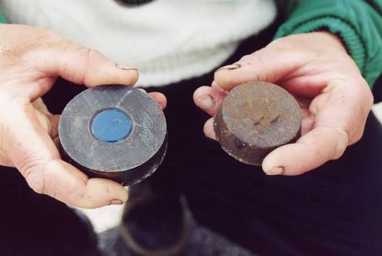 Deux palets d'acier dans les mains d'un joueur de palet sur terre